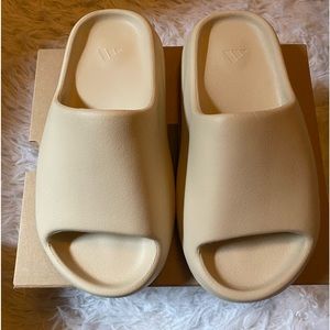 Yeezy slide made by adidas.